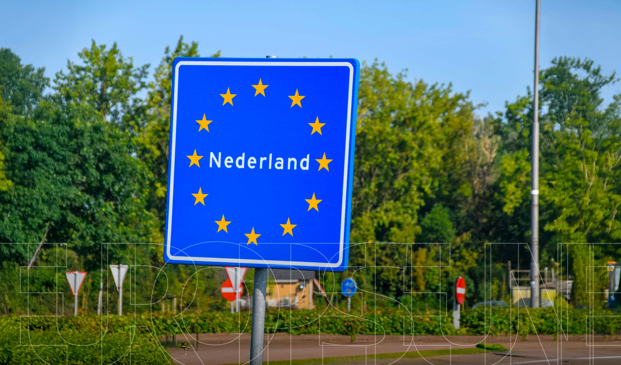 bord 'Nederland' met Europese sterren eromheen aan de grens
